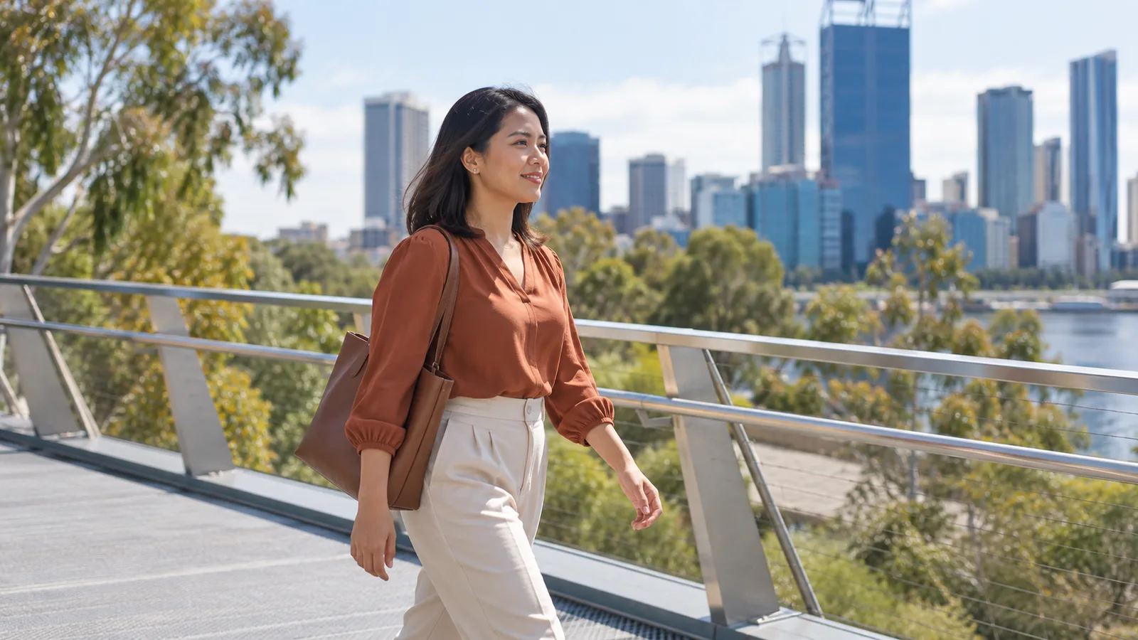 A Filipino professional walks across a Perth footbridge on her way through the city.